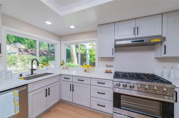 a kitchen with stainless steel appliances a stove a sink and cabinets