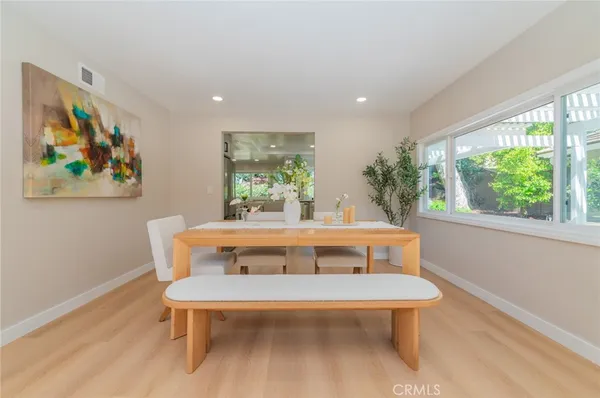 a view of a dining room with furniture a rug and wooden floor