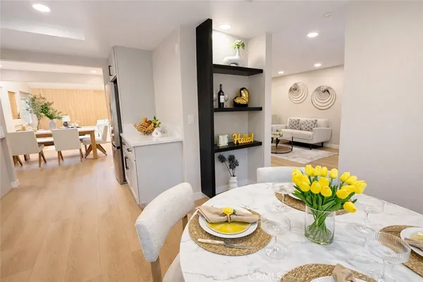 a dining room filled chandelier and wooden floor