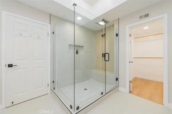 a bathroom with a shower and a glass door