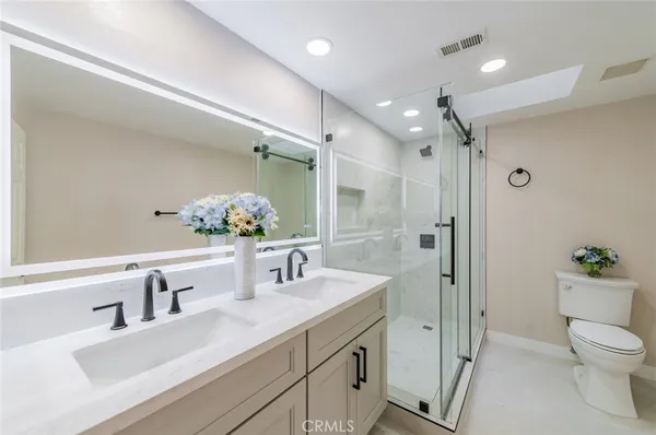 a bathroom with a sink a toilet and shower