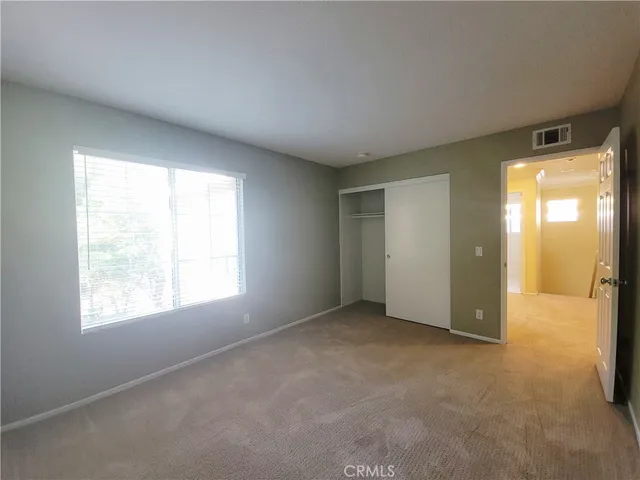 an empty room with windows and closet