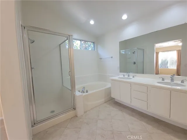 a spacious bathroom with a mirror a shower and vanity
