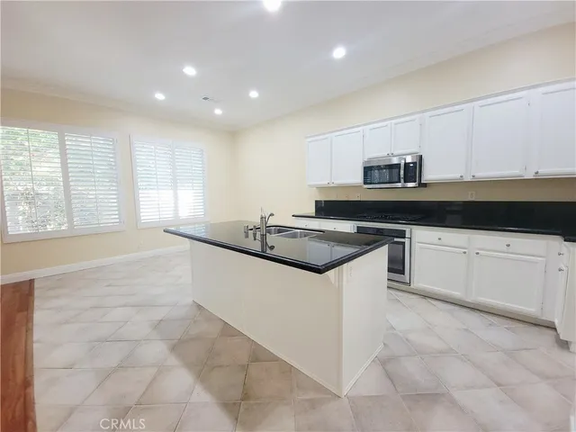 a kitchen with granite countertop a sink and a stove top oven