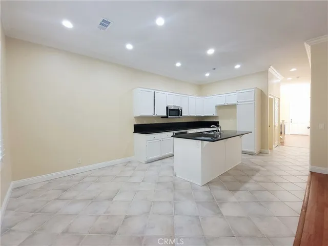 a large white kitchen with stainless steel appliances