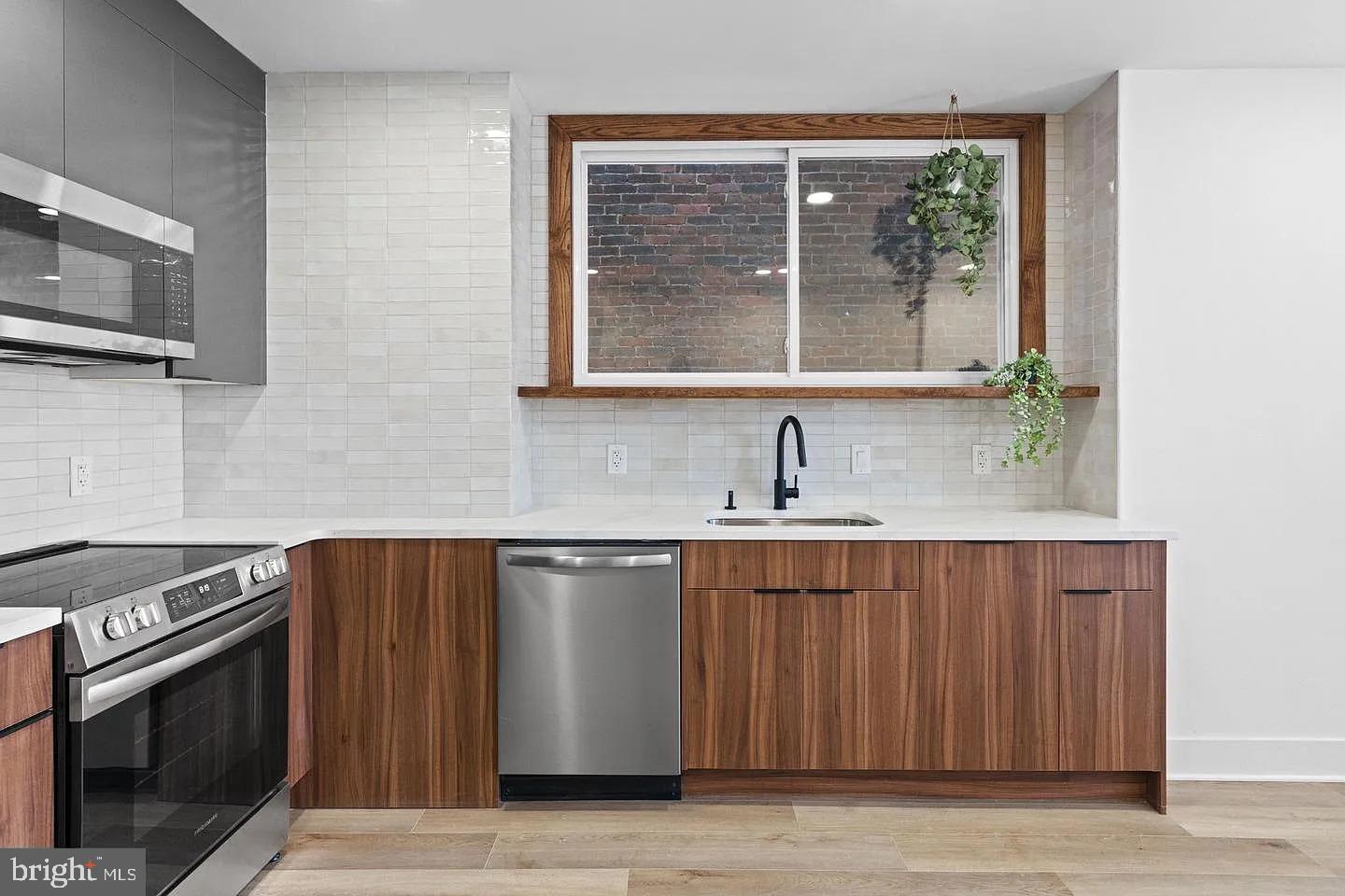1502 South 52nd Street, Unit A Philadelphia, PA 19143 - Photo 4 of 13 a kitchen with stainless steel appliances a stove sink and microwave