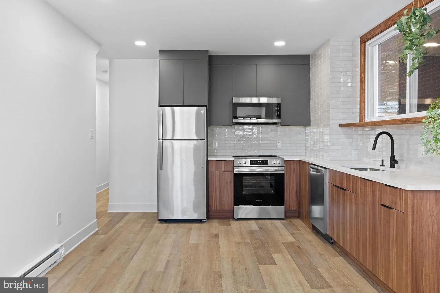 1502 South 52nd Street, Unit A Philadelphia, PA 19143 - Photo 5 of 13 a kitchen with stainless steel appliances a refrigerator and a sink