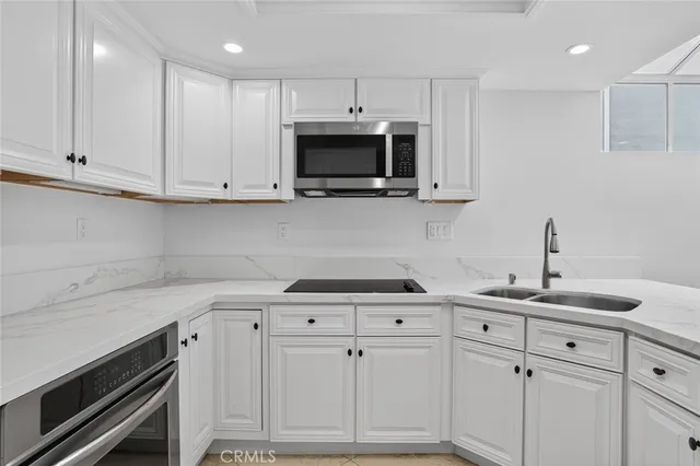 a kitchen with white cabinets stainless steel appliances and sink