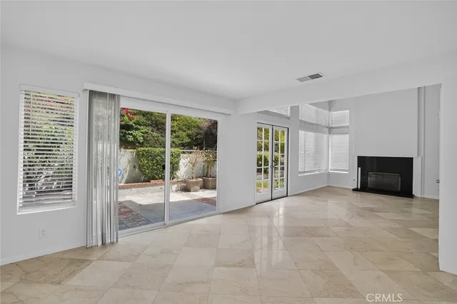 a view of an empty room with a fireplace and a window
