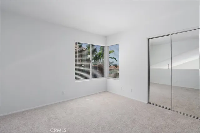 an empty room with windows and closet