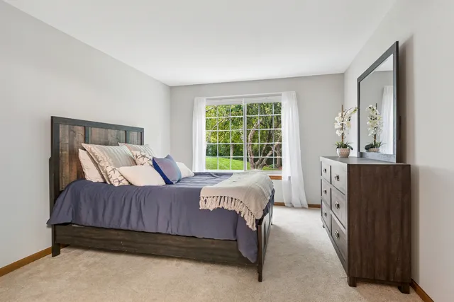 a bedroom with a bed a mirror and a window