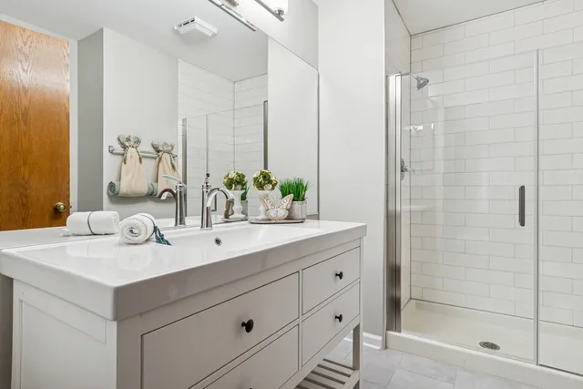 a bathroom with a shower sink and mirror