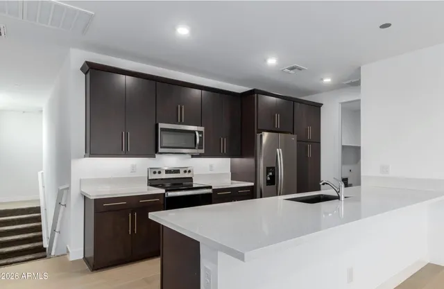 a kitchen with stainless steel appliances a refrigerator sink and microwave