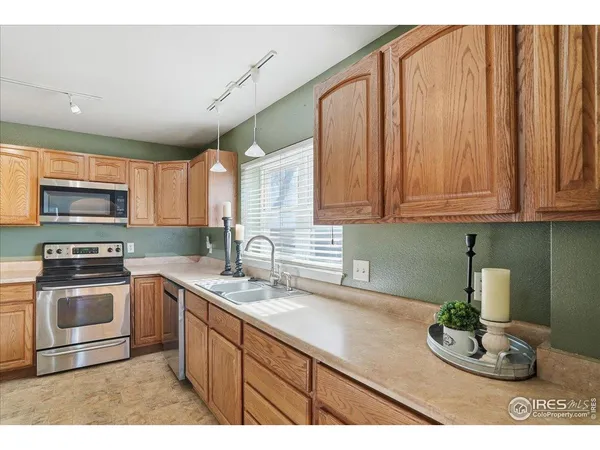 a kitchen with stainless steel appliances granite countertop a sink a stove a microwave cabinets and wooden floor