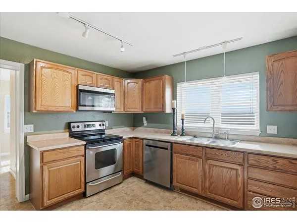 a kitchen with stainless steel appliances granite countertop a sink a stove cabinets counter space and a window
