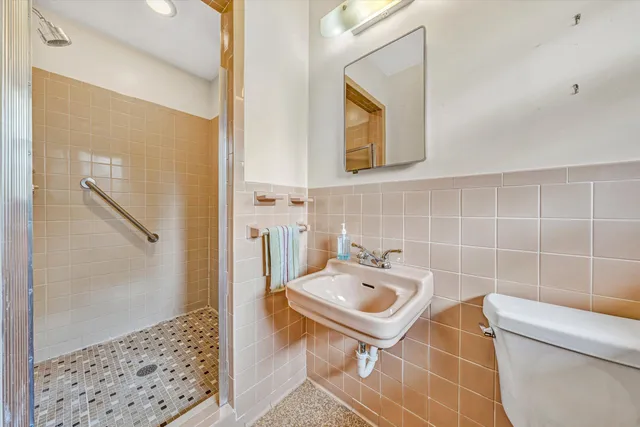 a bathroom with a sink a toilet and shower