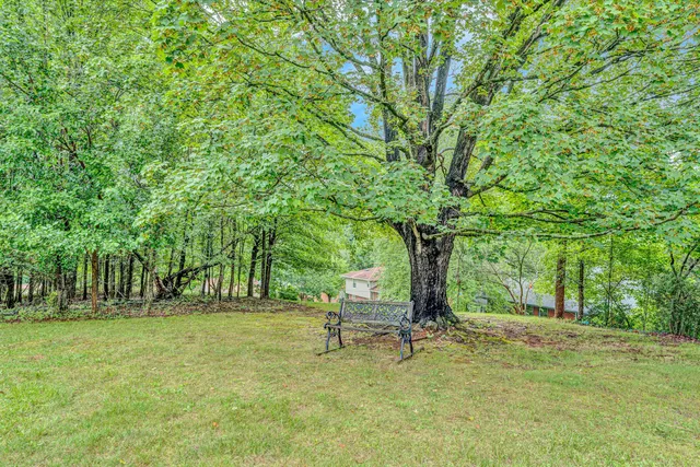 a backyard of a house with fountain table and chairs