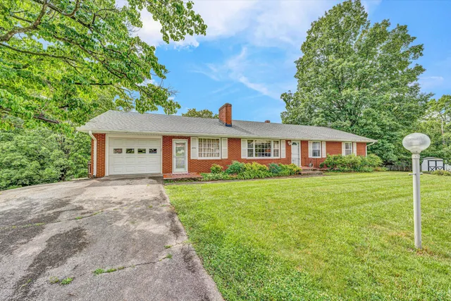 a front view of a house with a yard and trees
