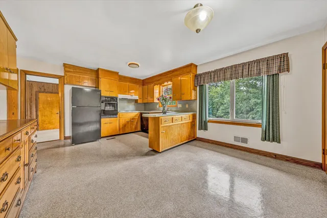 a open kitchen with stainless steel appliances granite countertop a refrigerator and a stove top oven