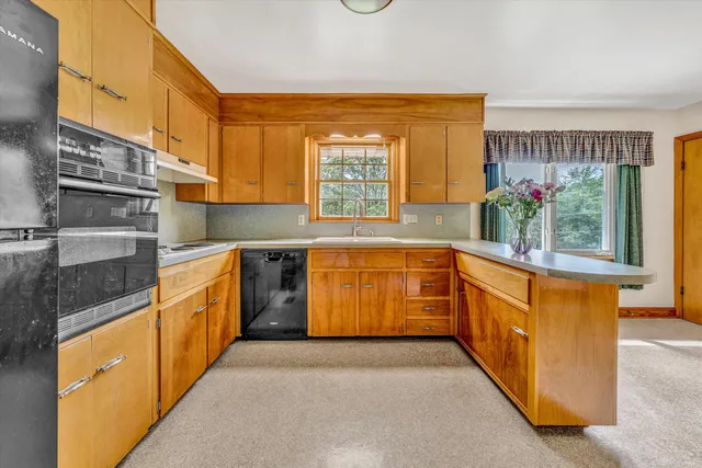 a kitchen with stainless steel appliances a sink and a large window