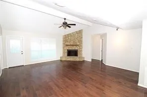 a view of an empty room with a fireplace and a window