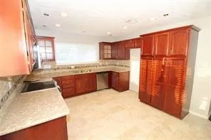 a large kitchen with stainless steel appliances granite countertop a sink and cabinets with wooden floor
