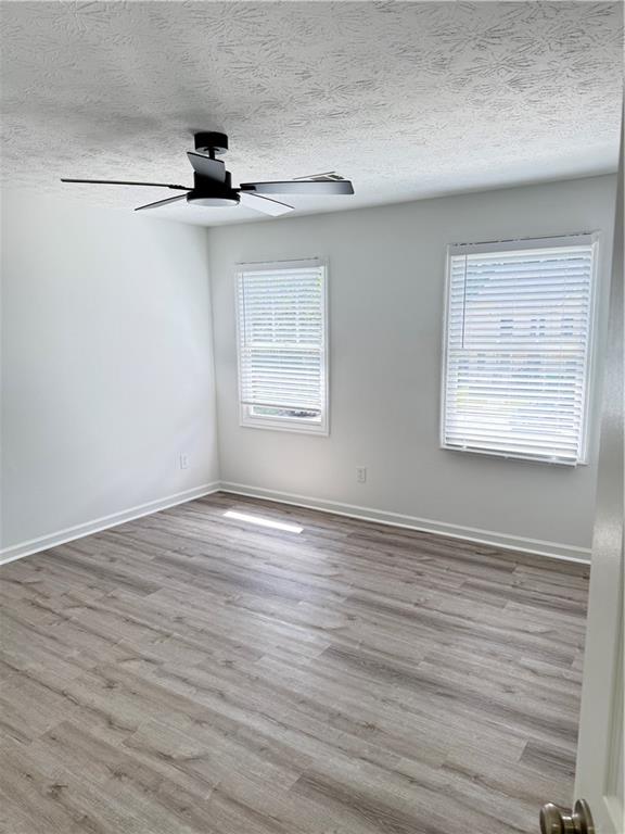 2356 Cove Road Lithonia, GA 30058 - Photo 18 of 20 an empty room with wooden floor fan and windows