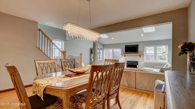 a view of a dining room with furniture a kitchen and chandelier
