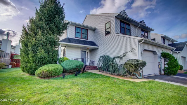 a front view of a house with a garden and plants