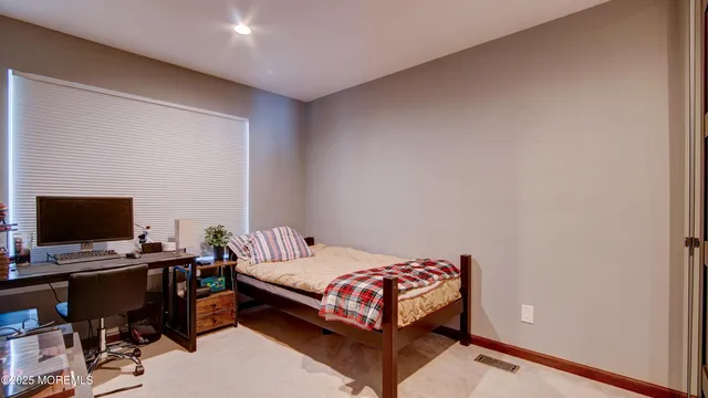 a bedroom with a bed and a computer on a desk