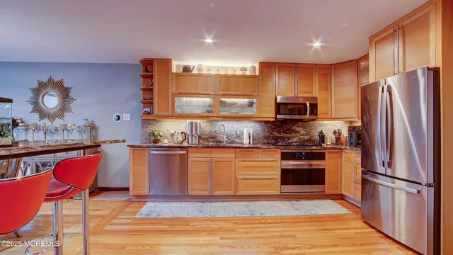 a kitchen with stainless steel appliances granite countertop a refrigerator stove microwave and sink