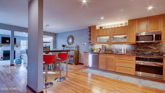 a kitchen with stainless steel appliances granite countertop a stove a sink and a refrigerator