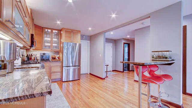 a kitchen with stainless steel appliances kitchen island granite countertop a refrigerator and a stove top oven