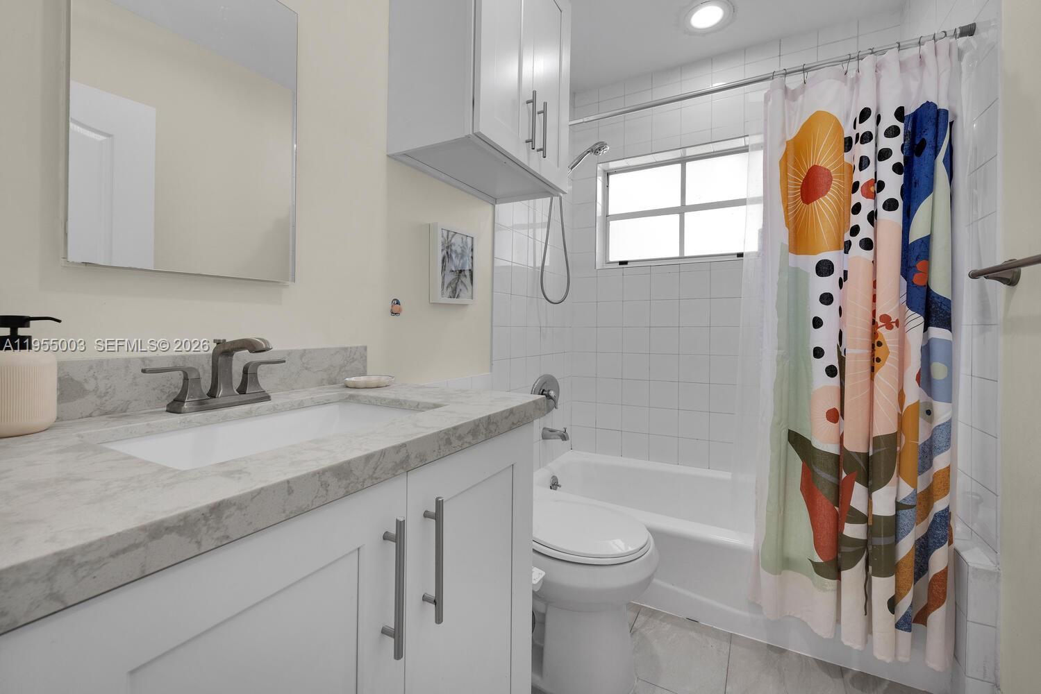 8230 Southwest 63rd Place Miami, FL 33143 - Photo 13 of 24 a bathroom with a granite countertop sink a toilet and shower