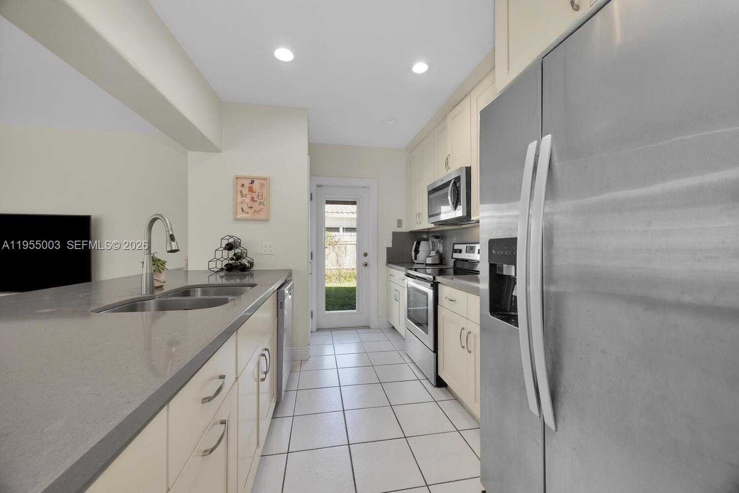 8230 Southwest 63rd Place Miami, FL 33143 - Photo 7 of 24 a kitchen with granite countertop a sink stove and refrigerator