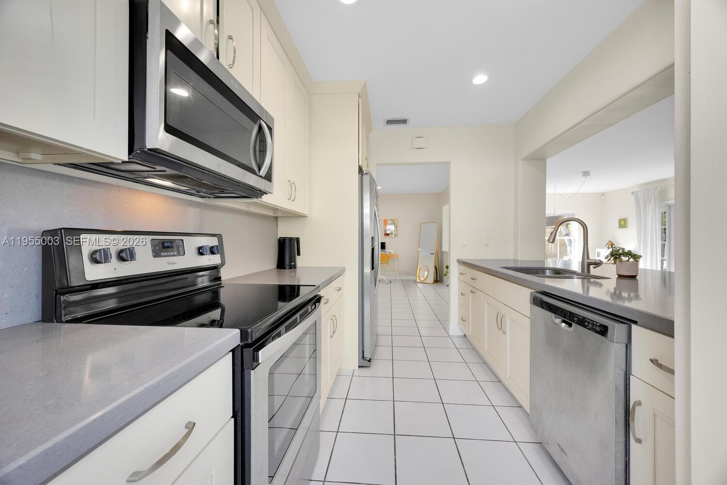 8230 Southwest 63rd Place Miami, FL 33143 - Photo 8 of 24 a kitchen with a stove microwave and sink
