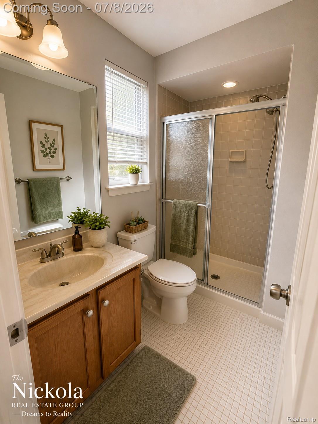 414 Whitney Drive Rochester, MI 48307 - Photo 25 of 30 Bathroom featuring a wood-finish vanity with a built-in sink, a large wall-mounted mirror, a commode, a glass-enclosed shower with subway tile surround, and square tile flooring