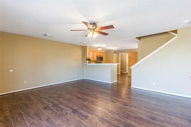a view of a kitchen with wooden floor and a ceiling fan