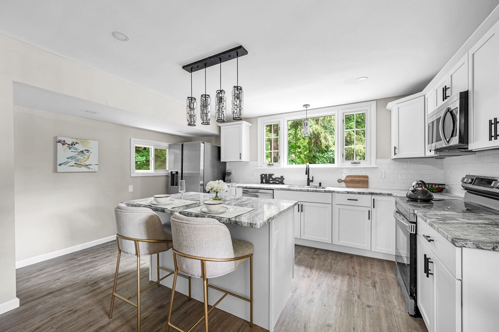 37 Bridge Street Monson, MA 01057 - Photo 32 of 35 a kitchen with stainless steel appliances granite countertop a stove a sink dishwasher and cabinets with wooden floor
