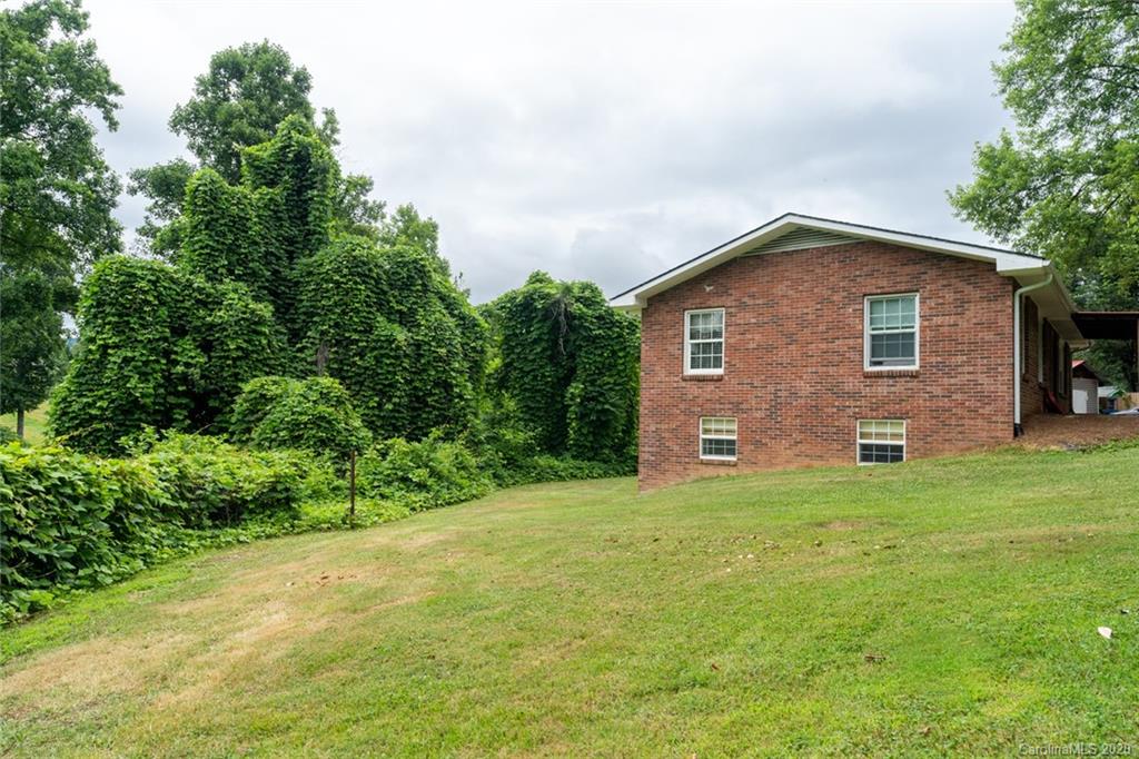 537 Souther Road Fletcher, NC 28732 - Photo 31 of 31 a brick house with a big yard plants and large trees