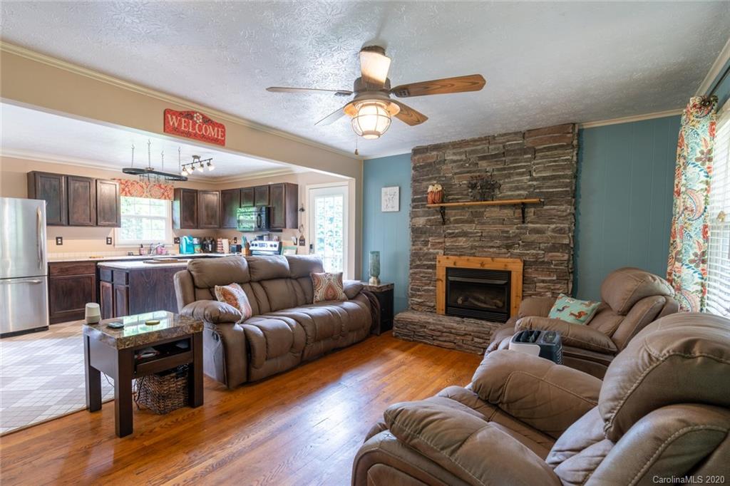 537 Souther Road Fletcher, NC 28732 - Photo 6 of 31 a living room with furniture a fireplace and a chandelier