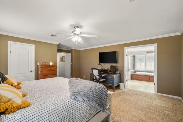 a bedroom with a bed and a flat tv screen on the dresser