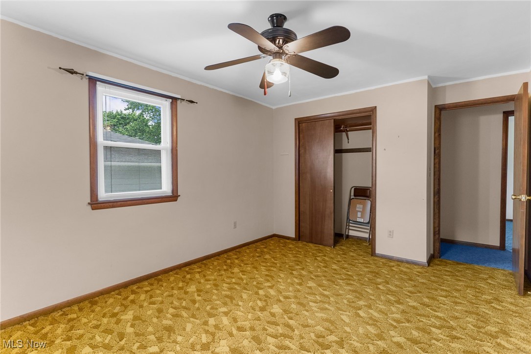1295 Shields Road Youngstown, OH 44511 - Photo 13 of 27 Unfurnished bedroom with baseboards, light carpet, a closet, crown molding, and ceiling fan