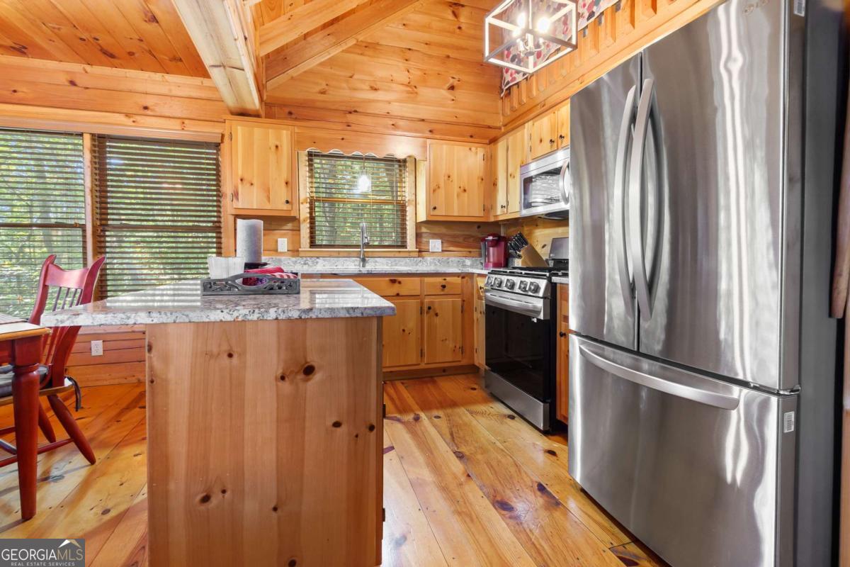 24 Casey Court Blue Ridge, GA 30513 - Photo 15 of 54 a kitchen with stainless steel appliances granite countertop a refrigerator a sink dishwasher a stove and white countertops with wooden floor
