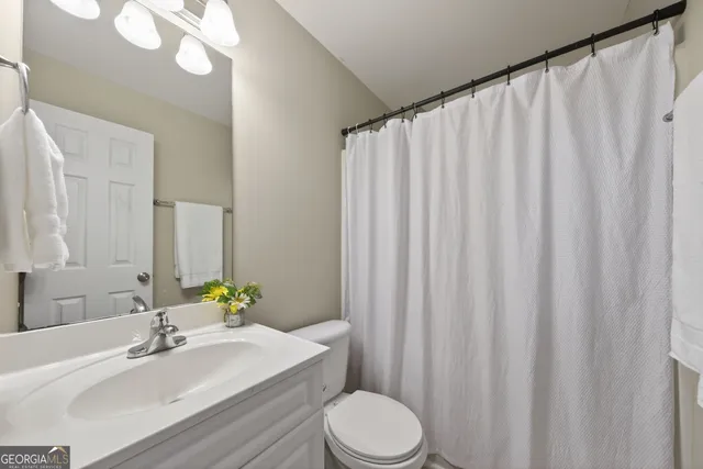 a bathroom with a sink a toilet and a mirror