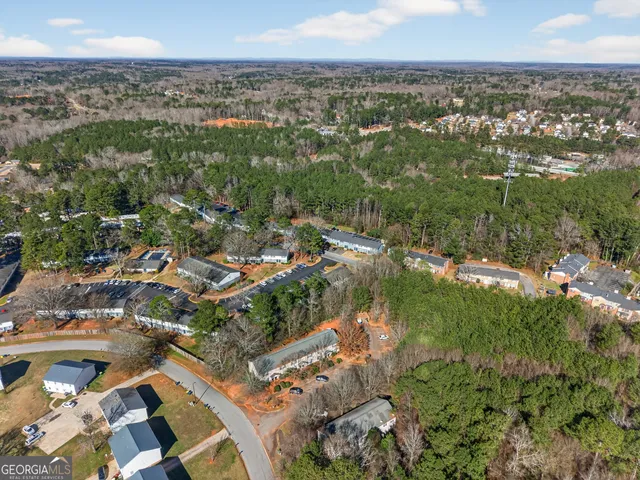 an aerial view of residential houses with outdoor space and trees