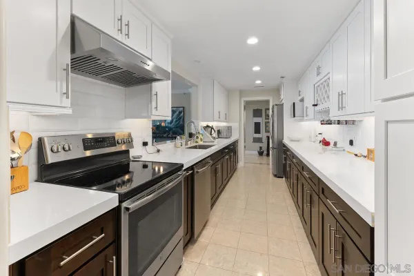 a kitchen with stainless steel appliances kitchen island granite countertop a refrigerator and stove