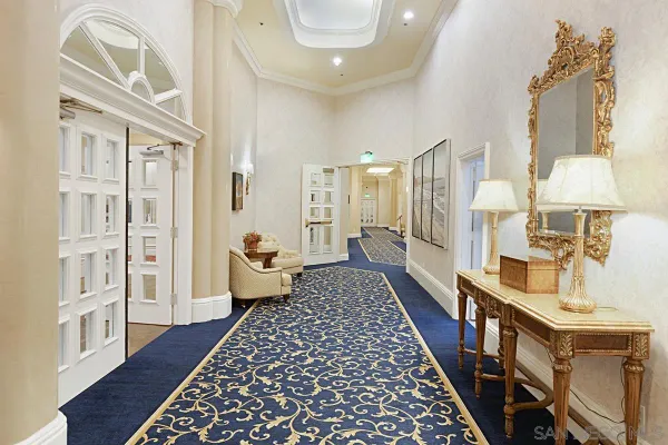 a room with lots of tables a chandelier and couches