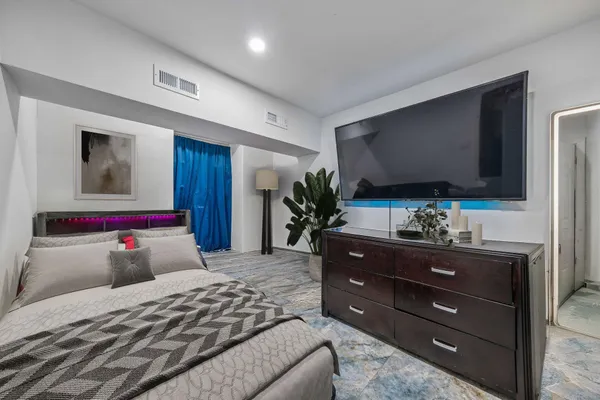a bedroom with a bed and a flat screen tv