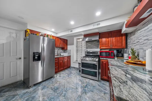 a kitchen with stainless steel appliances granite countertop a refrigerator and a stove
